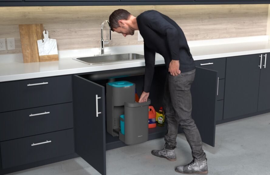 person opening compost bin under a sink