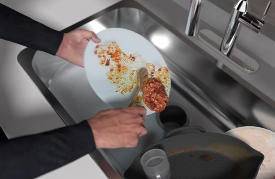 person scraping food off of plate into garbage disposal