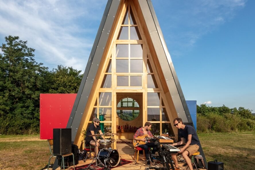 group of musicians jamming outside a triangular cabin