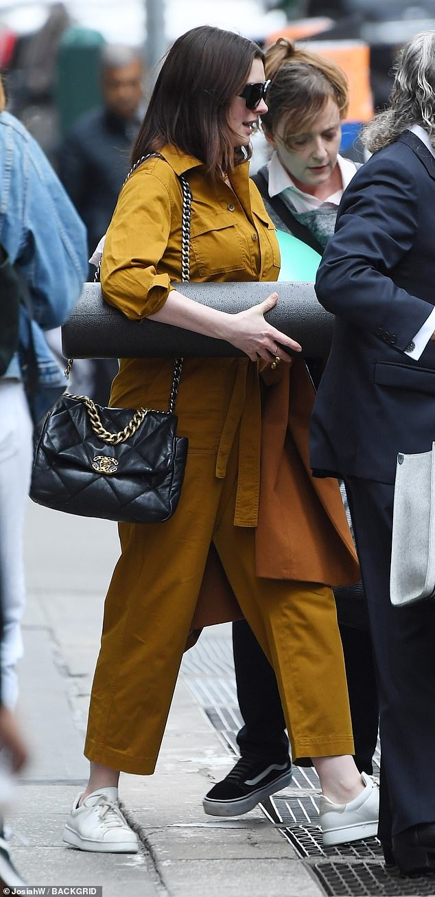 Mix and match: Her long hair was loose around her shoulders and she carried a large foam roller used for exercising and a black Chanel shoulder purse