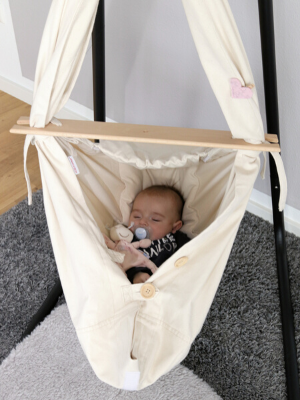 Beige Babyfederwiege von HOBEA mit Baby im Kinderzimmer