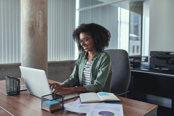 woman using a laptop computer in an office to duplicate a page in WordPress