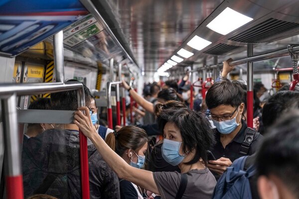 Travelers on the subway in Hong Kong this month. The city is seeing another surge in Covid-19 cases.