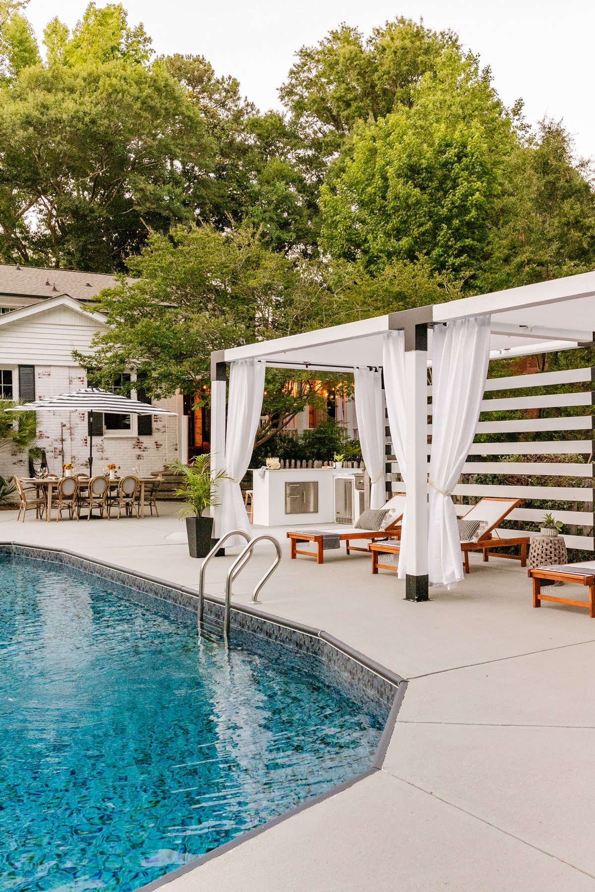 backyard with pool outdoor kitchen pergola cabana and outdoor dining table