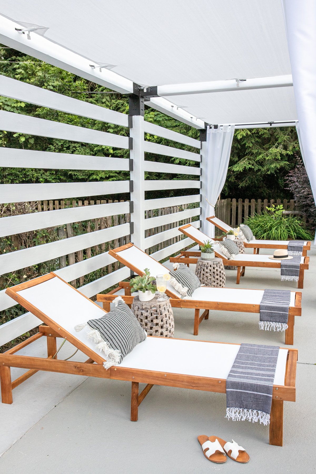 pool lounge chairs under a white DIY pergola