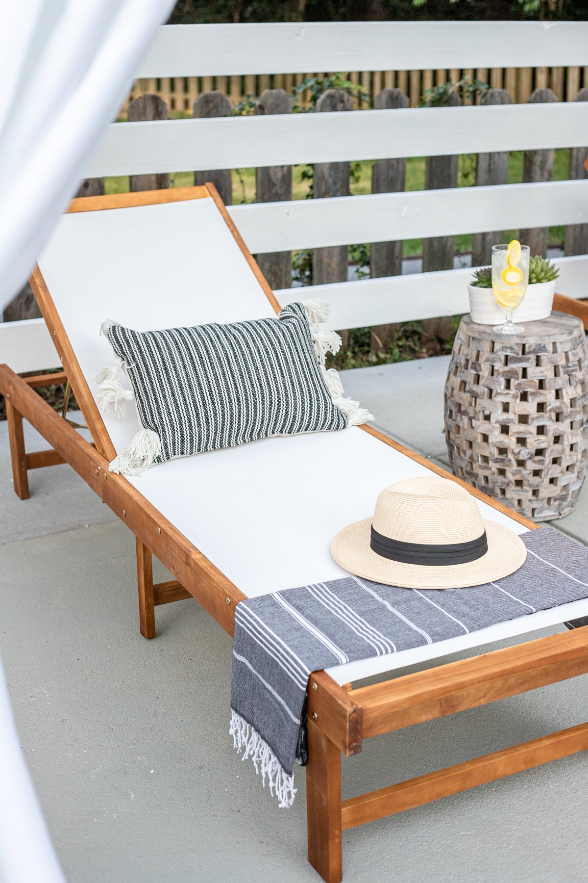 outdoor lounge chair with pillow, turkish towel, and sun hat