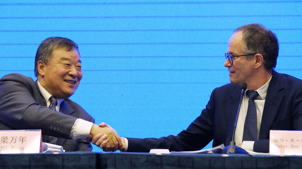 Peter Ben Embarek, of the World Health Organization team (right) shakes hands with Liang Wannian, his Chinese counterpart, after a news conference on Tuesday in Wuhan, China. The White House says it has "deep concerns" over how initial findings were communicated.